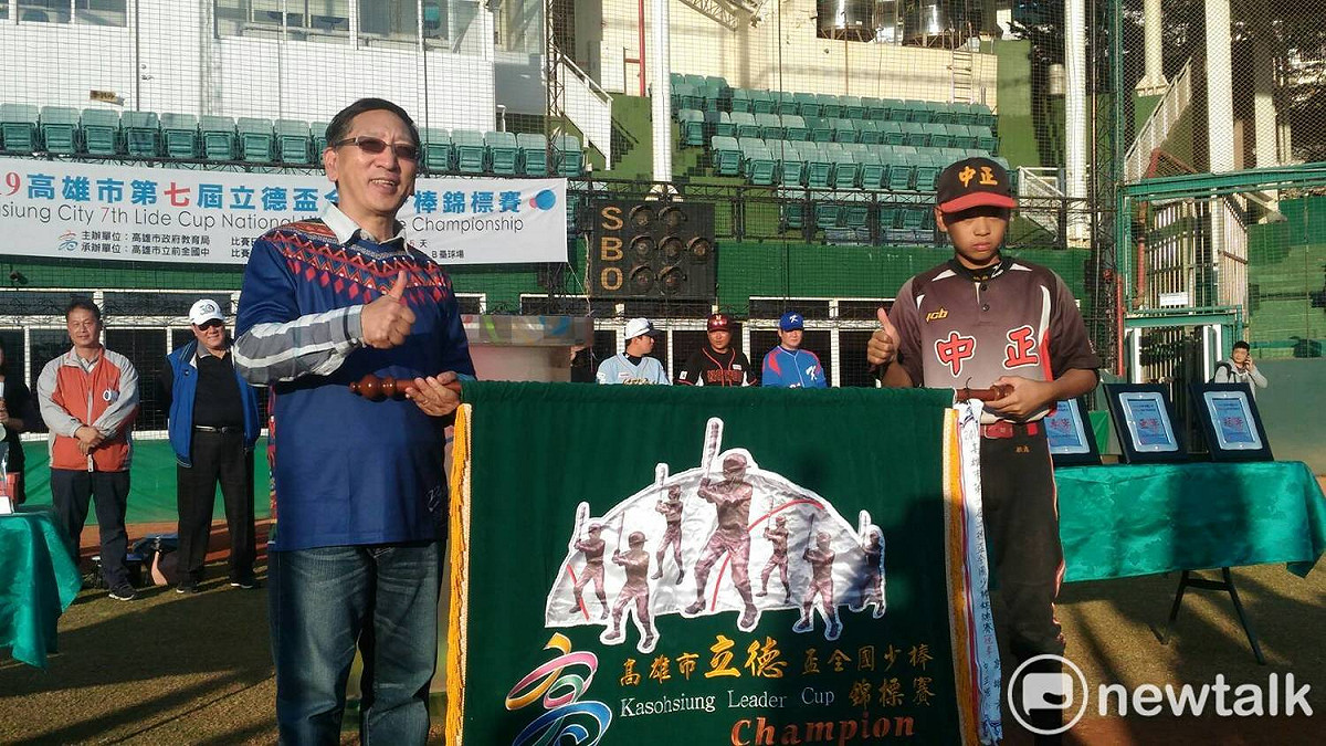 去年冠軍中正國小將冠軍旗交回給教肓局長吳榕峯(左)。 圖：孫家銘／攝