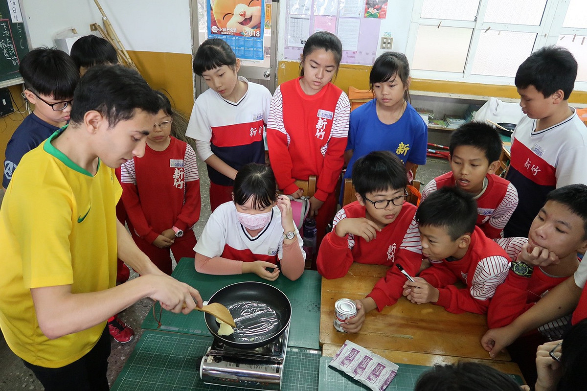 巴西留學生丹尼斯為新竹國小學童現場示範製作巴西巧克力糖球。 圖 : 廣達/提供