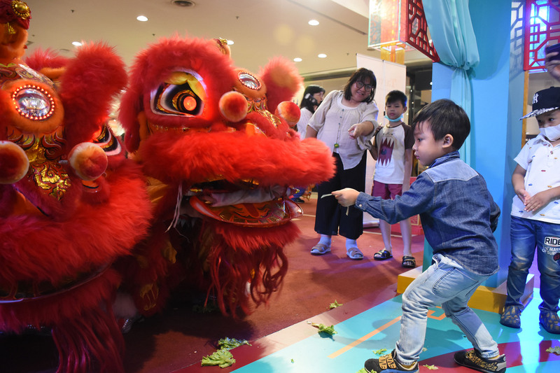 觀光局駐曼谷辦事處和泰國商場以及泰國南瑤媽祖宮合作，在商場一樓設置攤位，主打台灣宗教旅遊。圖為小朋友和舞龍舞獅互動。 圖：中央社
