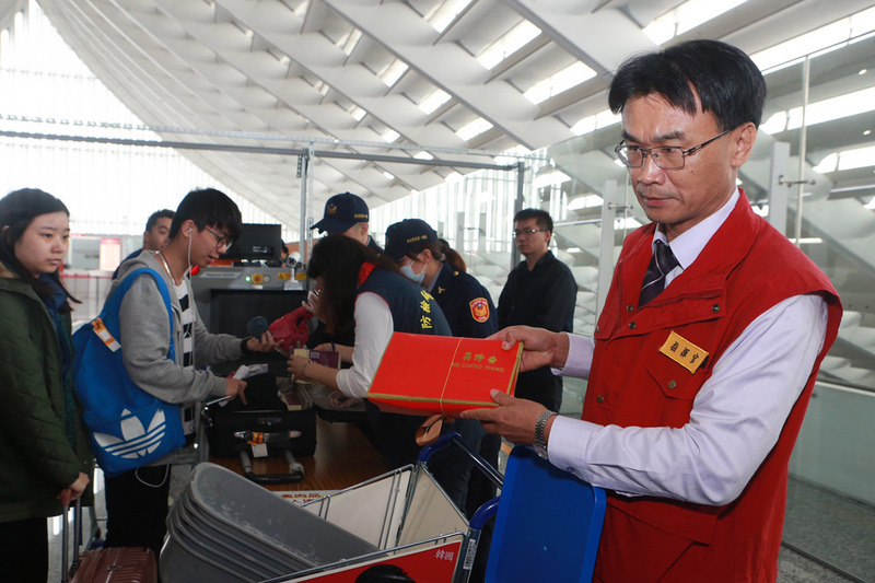桃園國際機場2日啟用X光機進行中港澳旅客手提行李的防疫檢查，農委會主委陳吉仲（右1）前往桃園機場第一航廈視察，並親自向旅客宣導疫區與非疫區的分流措施。 圖：中央社