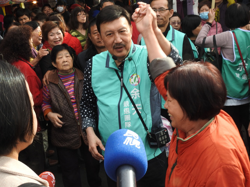 春節連假首日，民進黨籍新北市立委補選參選人余天（中）2日到三重力行市場拜票，受到攤商及婆婆媽媽熱烈歡迎。 圖：中央社