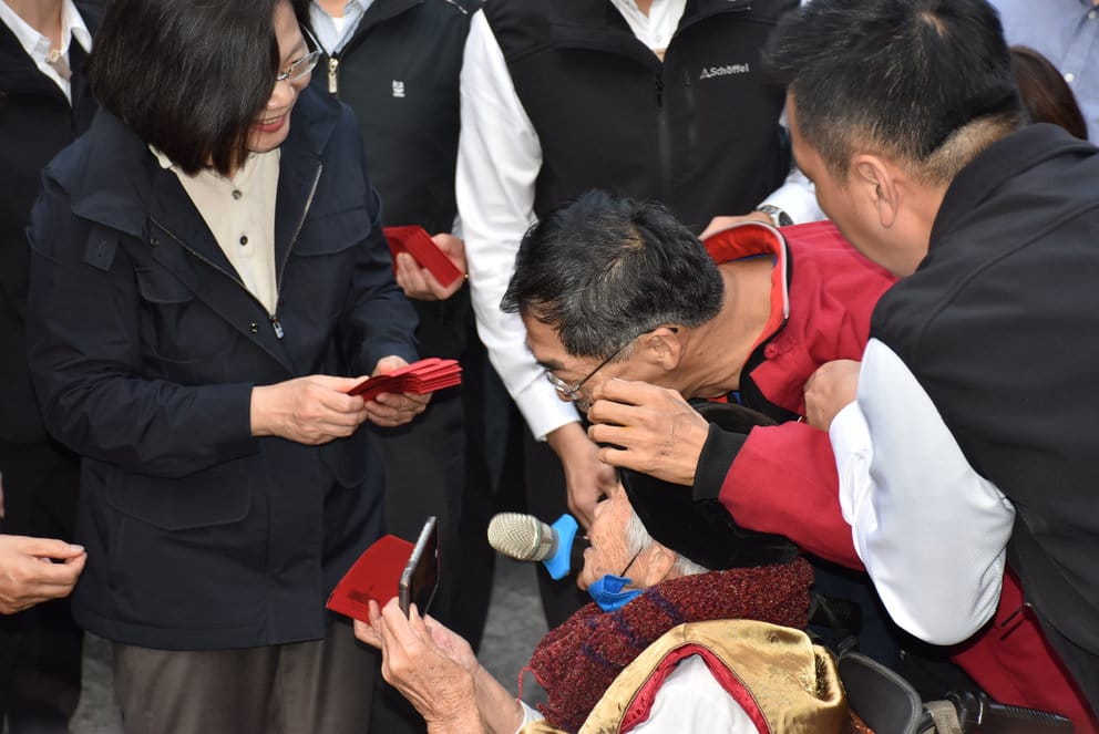 嗆蔡英文的紅衣男拿出麥克風遭維安阻擋。 圖：孫家銘／攝