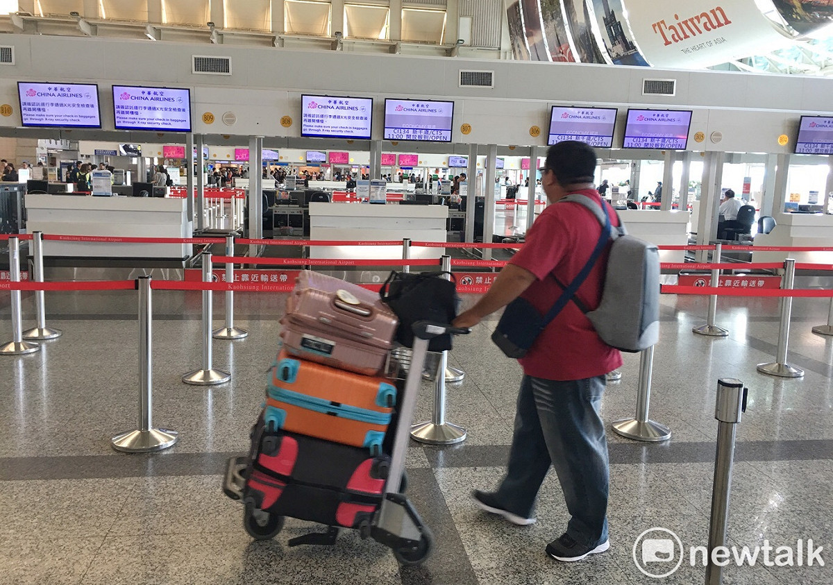 一位將出境旅客推著行李經過高雄小港國際機場華航報到櫃檯。 圖：張良一攝