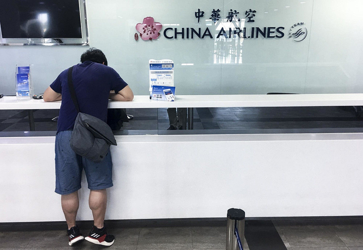 桃園機師工會華航分會發動機師罷工首日，高雄小港國際機場的華航航班多班取消，一位華航旅客在華航櫃檯詢問轉機事宜。 圖：張良一/攝