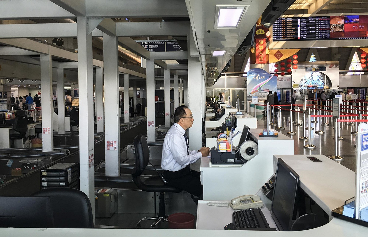 高雄小港國際機場的華航航班因機師罷工導致多班取消，華航地勤人員坐在華航報到櫃台內。 圖：張良一/攝