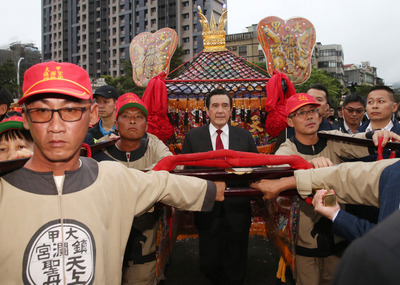 總統馬英九（中）16日在台北出席「2019大甲媽祖北巡祈安遶境祈福駐駕安座典禮」，媽祖鑾轎抵達時，馬英九親自扶轎。 圖：中央社