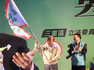 民進黨籍新北市立委補選參選人余天（右）17日晚間在三重區舉辦造勢晚會，行政院長蘇貞昌（左）出席站台，並為余天授旗。 圖：中央社