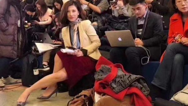 照片顯示，梁相宜不再穿當初的那套搶鏡的藍色套裝，改以乳白色外套，下身搭紅色裙子。從梁相宜一身打扮看起來，今年已改走柔色系，也增添了幾許落落大方。然而，當時她的身旁新聞界同業們，個個聚精會神作筆記、打電腦或拍照攝影，唯獨梁相宜以詭異的角度，斜倚著身，交叉雙腿，凝視著鏡頭，看似告訴大家「我回來了！」

 圖：翻攝自微博