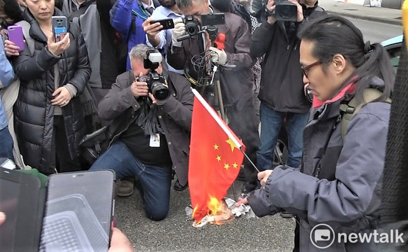 中國電信大廠華為財務長孟晚舟6日在加拿大出庭，法庭外有人焚燒五星旗，抗議中國政府侵害人權。 圖 : 中央社