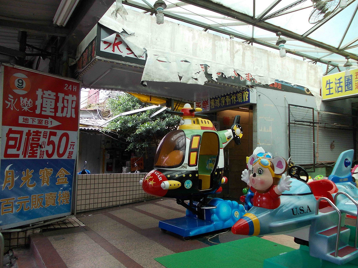 永樂撞球運動休閒館的入口懸掛招牌違建，遭強制拆除；圖為拆除前。 
 圖：新北市衛生局提供