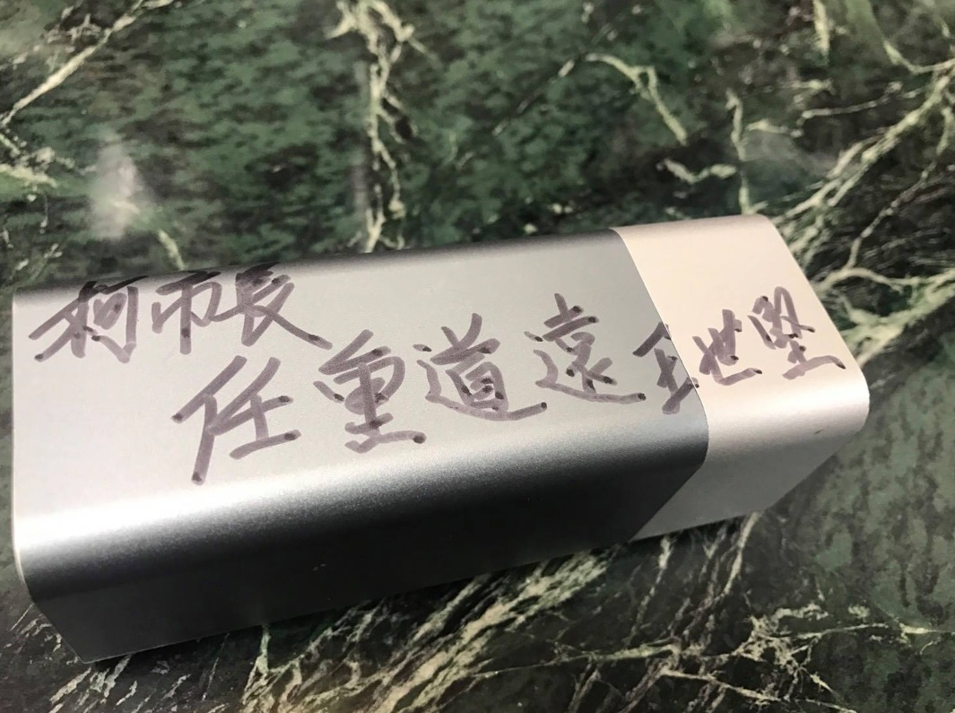 王世堅送柯文哲行動電源，還在上面寫「任重道遠」四字做為提醒。 圖: 翻攝自王世堅臉書