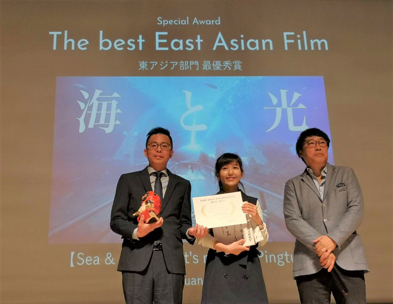 2019台灣燈會宣傳音樂影片「海與光（我們屏東見吧！）」，勇奪第一屆日本國際觀光影像節最佳東亞影像獎，屏縣府傳播暨國際事務處長黃建嘉（左）與創作者黃小玫（中）14日一同出席領獎。 圖：屏東縣政府/提供