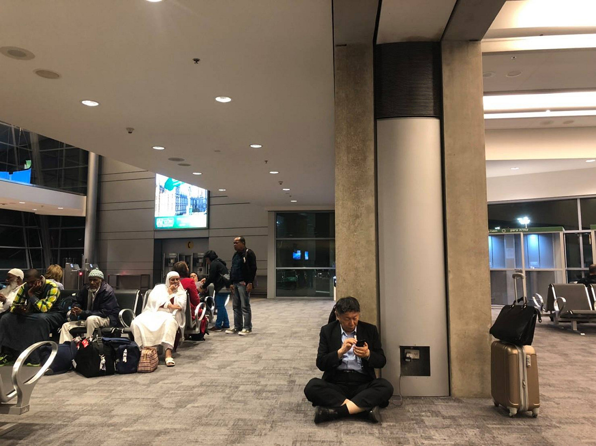 柯文哲上個月訪以色列返國時，在臉書PO出一張坐在機場充電的照片，遭王世堅酸是「假親民、假隨興」。 圖：翻攝自 柯文哲臉書