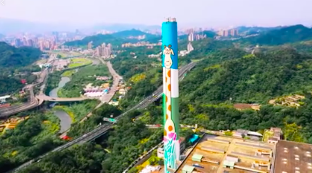 台北市環保局今（16）日在臉書表示，台北市木柵焚化爐的煙囪彩繪長頸鹿完成了。 圖：截自台北市環保局影片