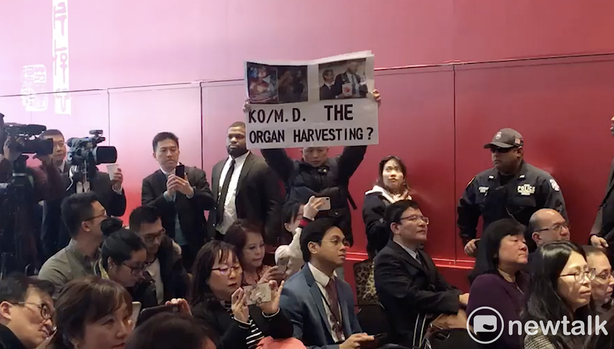 台灣國辦公室主任陳峻涵於台北市長柯文哲在駐紐約辦事處的永續發展簡報會演說上高舉「器官移植」海報抗議。 圖：台灣國辦公室 / 提供