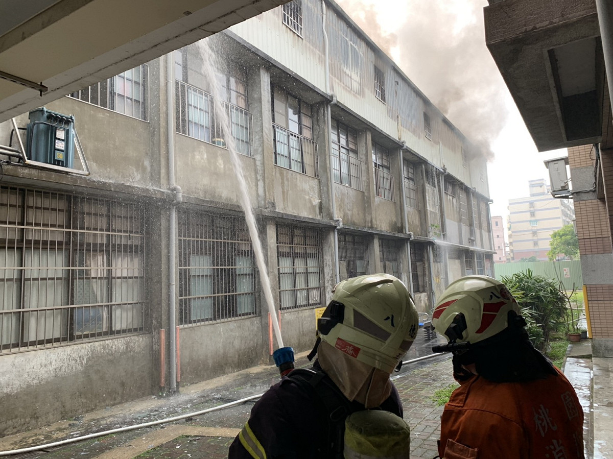 八德國小傳出校園火警，疑因三樓加蓋鐵皮屋儲藏室起火，冒出濃烈黑煙。 圖：桃園市政府消防局／提供