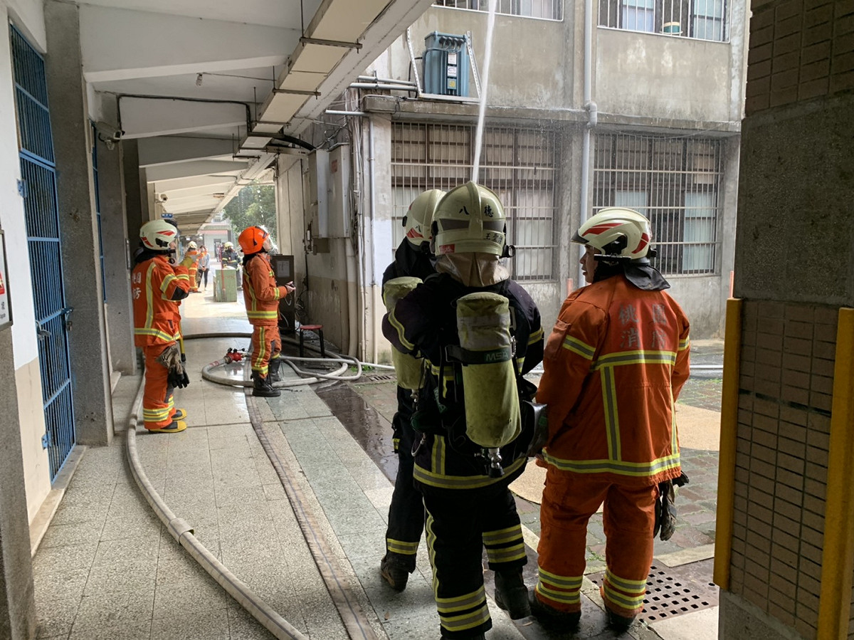 消防人員拉水線撲滅火勢，全校師生集合操場清點人數，所幸無人受困。 圖：桃園市政府消防局／提供