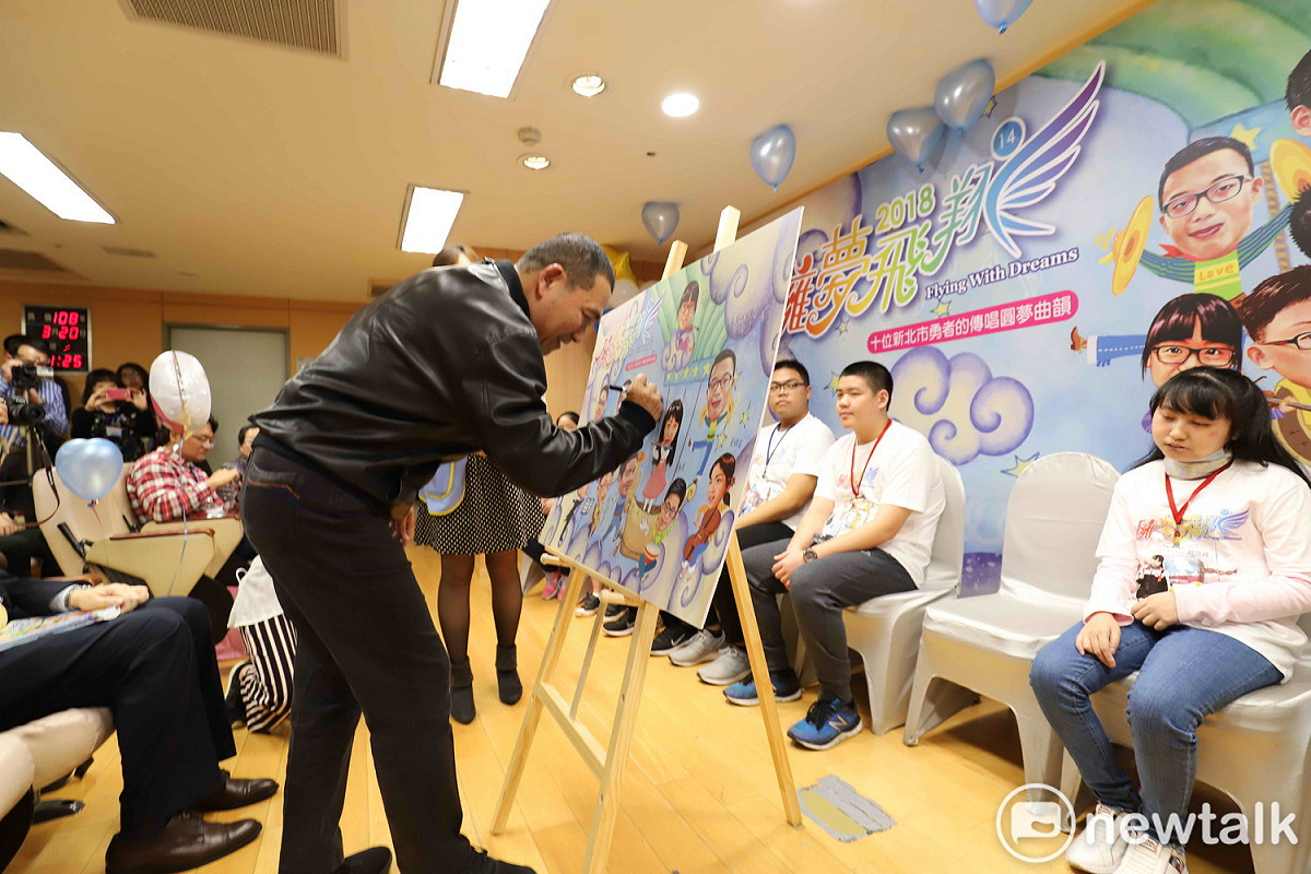 侯友宜在《擁夢飛翔14》新書發表會的擁夢拼圖上簽名，肯定10位生命勇者的奮鬥不懈。 圖：王峻昌/攝
