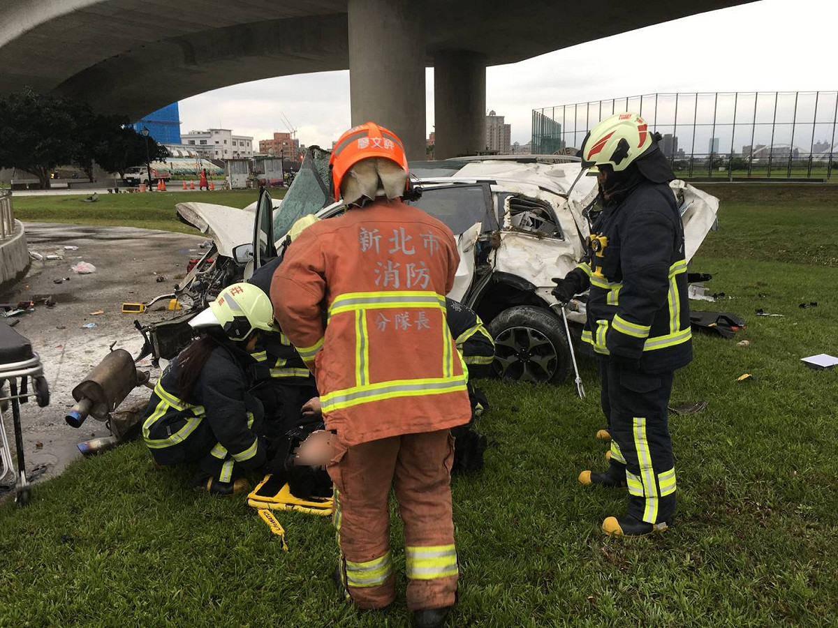 一台休旅車從台65快速道路墜落重新堤外便道，車體嚴重變形，駕駛死亡。 圖/新北市消防提供