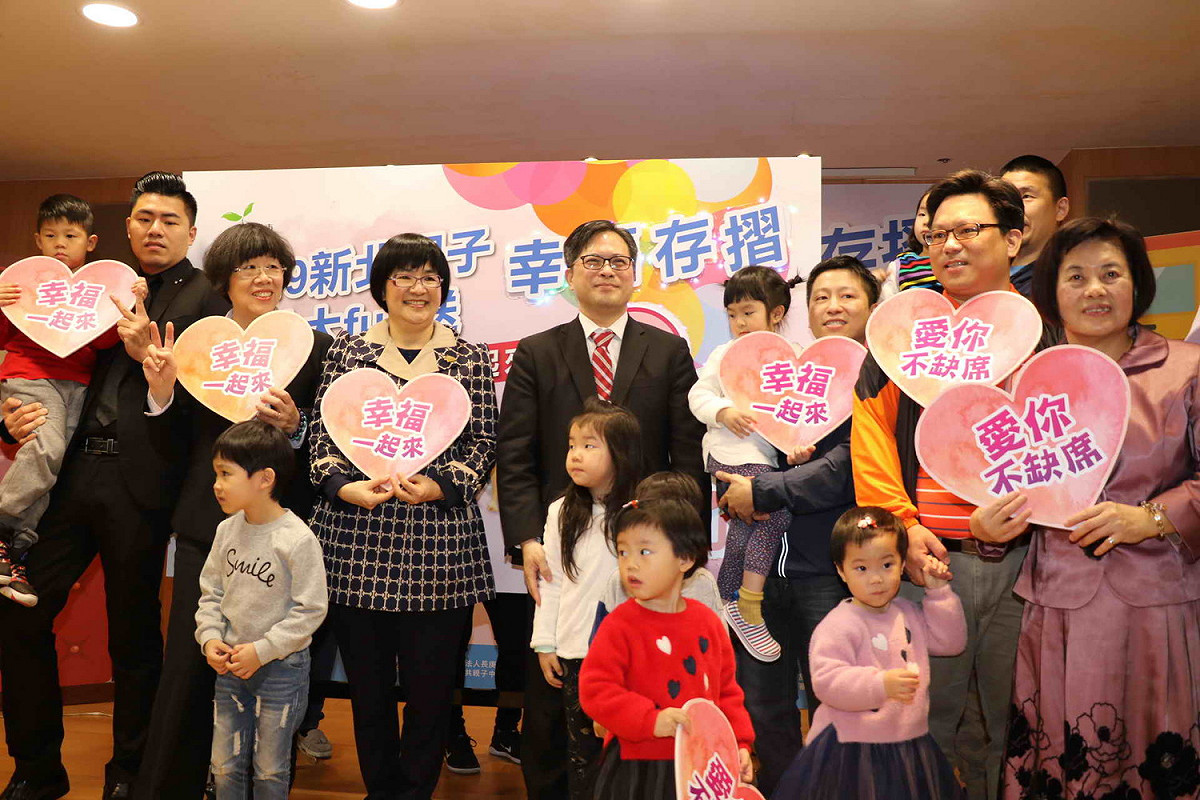 新北市「親子幸福存摺集點大FUN送」活動，由副市長吳明機(左五)、社會局長張錦麗(左四)及家長親子代表們，宣布活動起跑。 圖：新北市社會局/提供