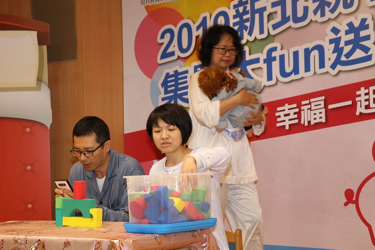 「親子幸福存摺集點大FUN送」記者會，以行動劇顯示媽媽忙成一團，爸爸卻在一旁滑手機，也不陪孩子玩積木。  圖：新北市社會局/提供