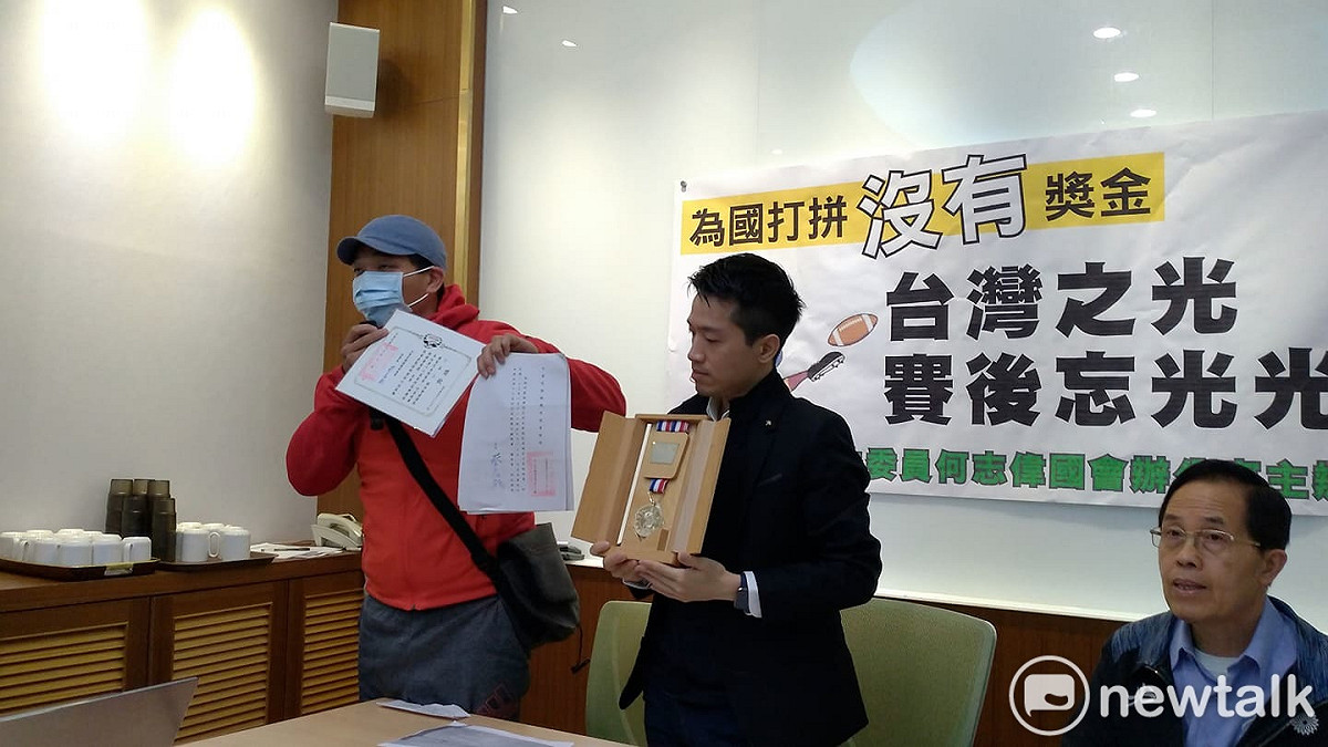 選手嚴先生秀出獎章陳情。 圖:陳佩君/攝