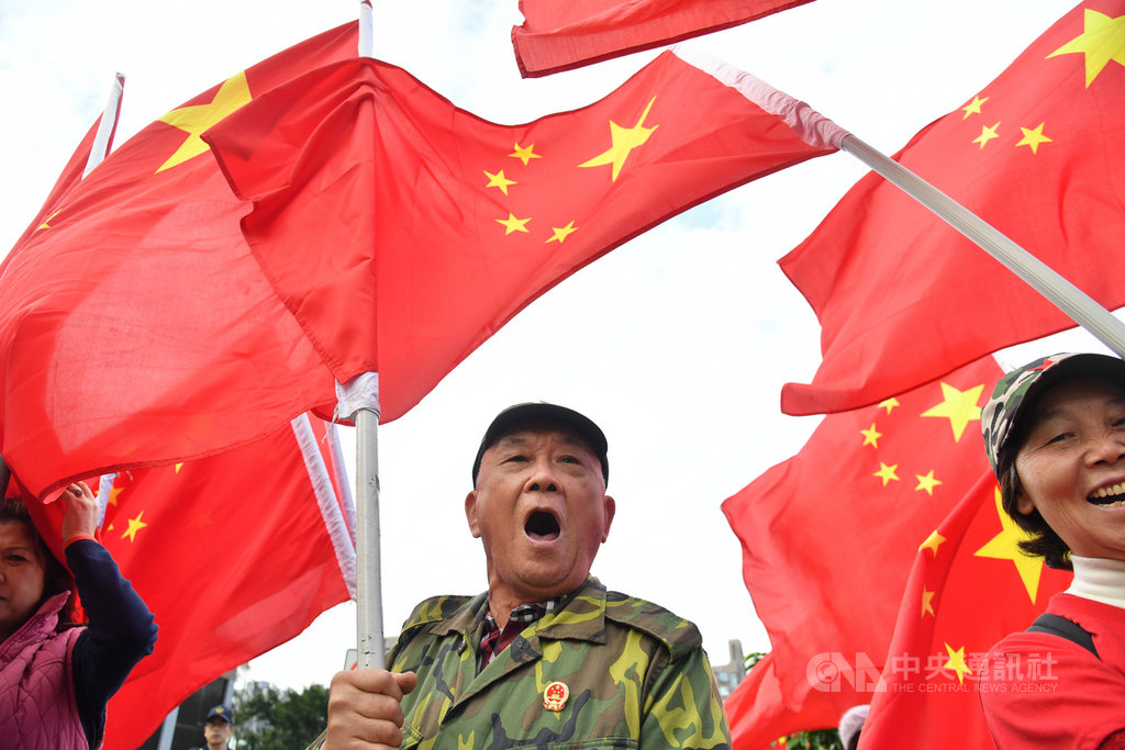 學者吳介民指出，台灣是民主小國，本身還有統獨認同與藍綠分歧，更有一群為數不少的人希望成為「中華人民共和國的人」，在因應「中國因素」上比較辛苦。圖為民眾在台北街頭高舉五星旗。 圖/中央社