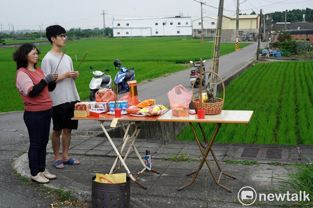 彰化溪州兩位民眾在路旁擺設供桌，向經過的白沙屯媽祖上香祈福。 圖：張良一/攝