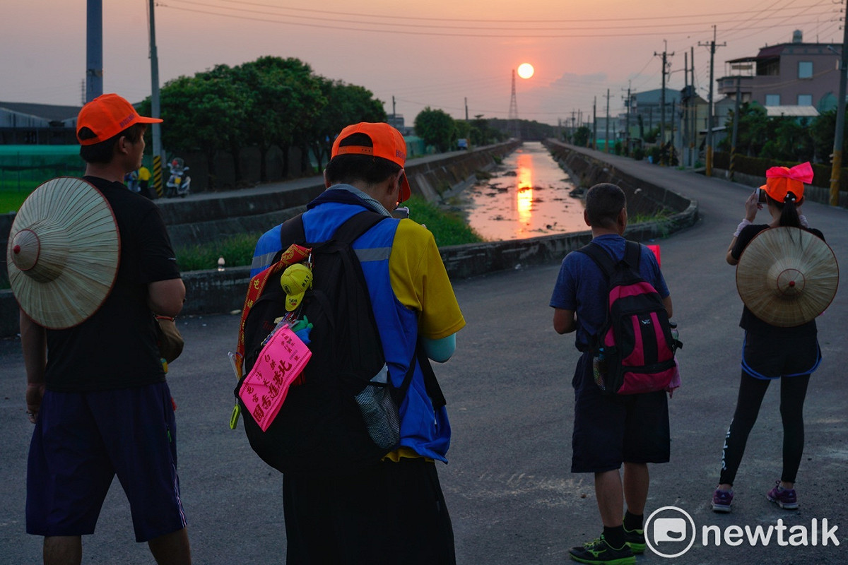一些徒步信眾傍晚時分停下腳步拍攝夕陽。 圖：張良一/攝