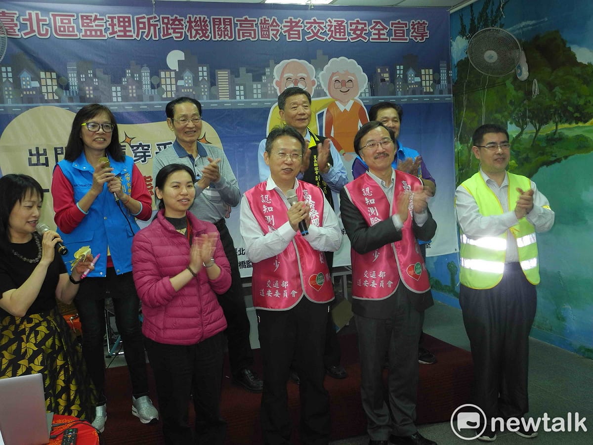 臺北區監理所長王在莒 (前排右三)、福德里長劉慧琳 (後排左一)等人，呼籲長者「出門衫褲穿乎金，一路平安熊放心」。 圖：王峻昌/攝