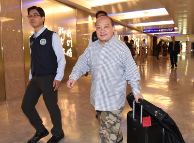 曾鼓吹武力統一台灣的中國學者李毅（右）12日清晨遭 強制出境，被問到是否感到可惜，他嘆氣說，「緣分、 緣分」。 圖：中央社
