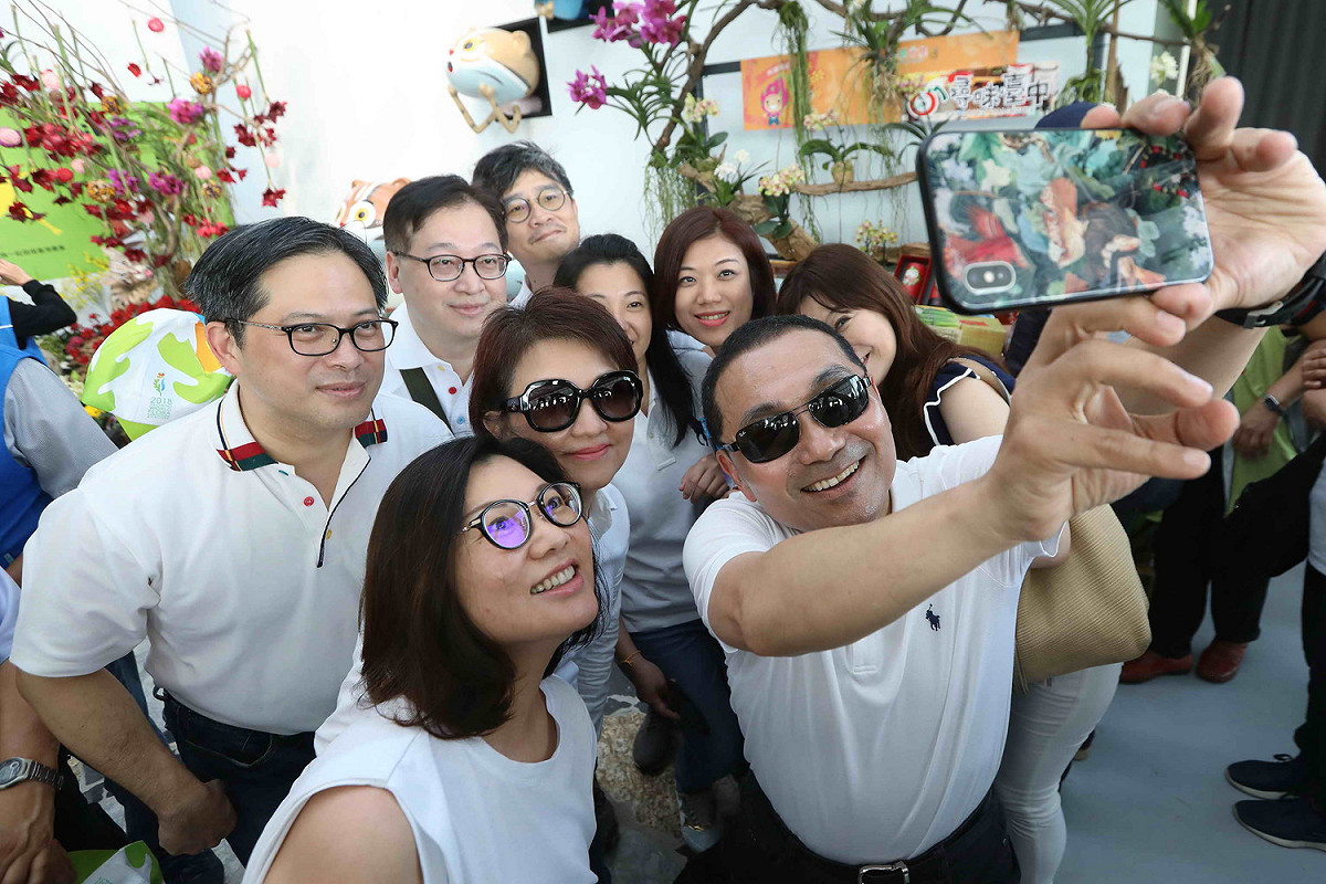 新北市長侯友宜（前排右）率市府團隊參訪台中花博，與台中市長盧秀燕（中）一起玩自拍。 圖：新北市政府提供