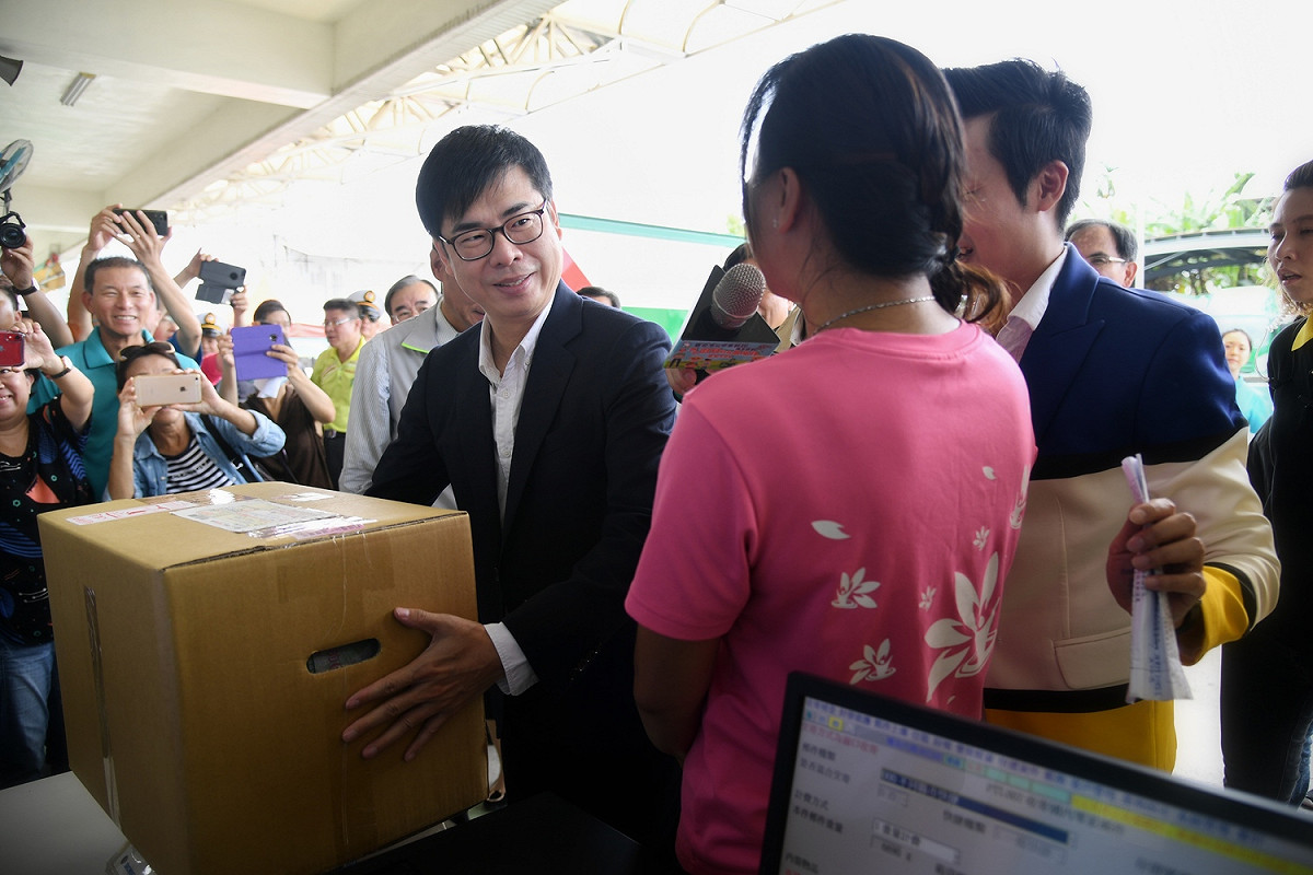 陳其邁幫忙搬運貨品。 圖：行政院提供
