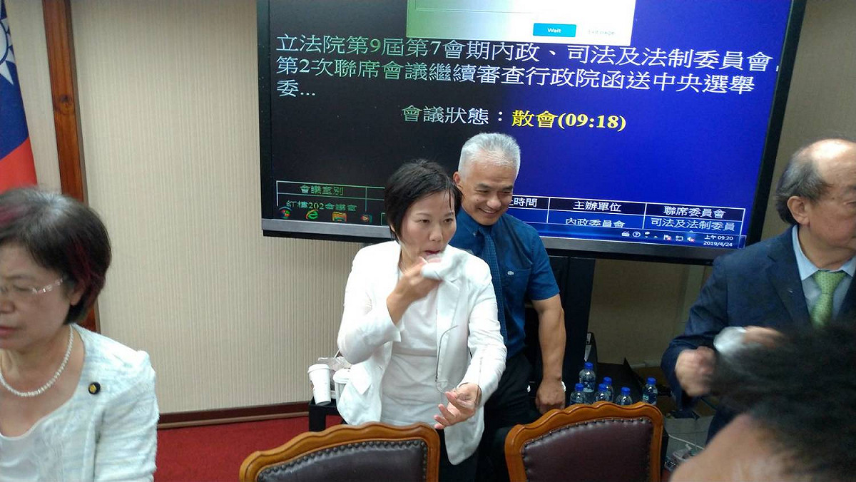 藍委朝綠委潑水，綠委劉世芳拿衛生紙擦臉。 圖：陳佩君／攝