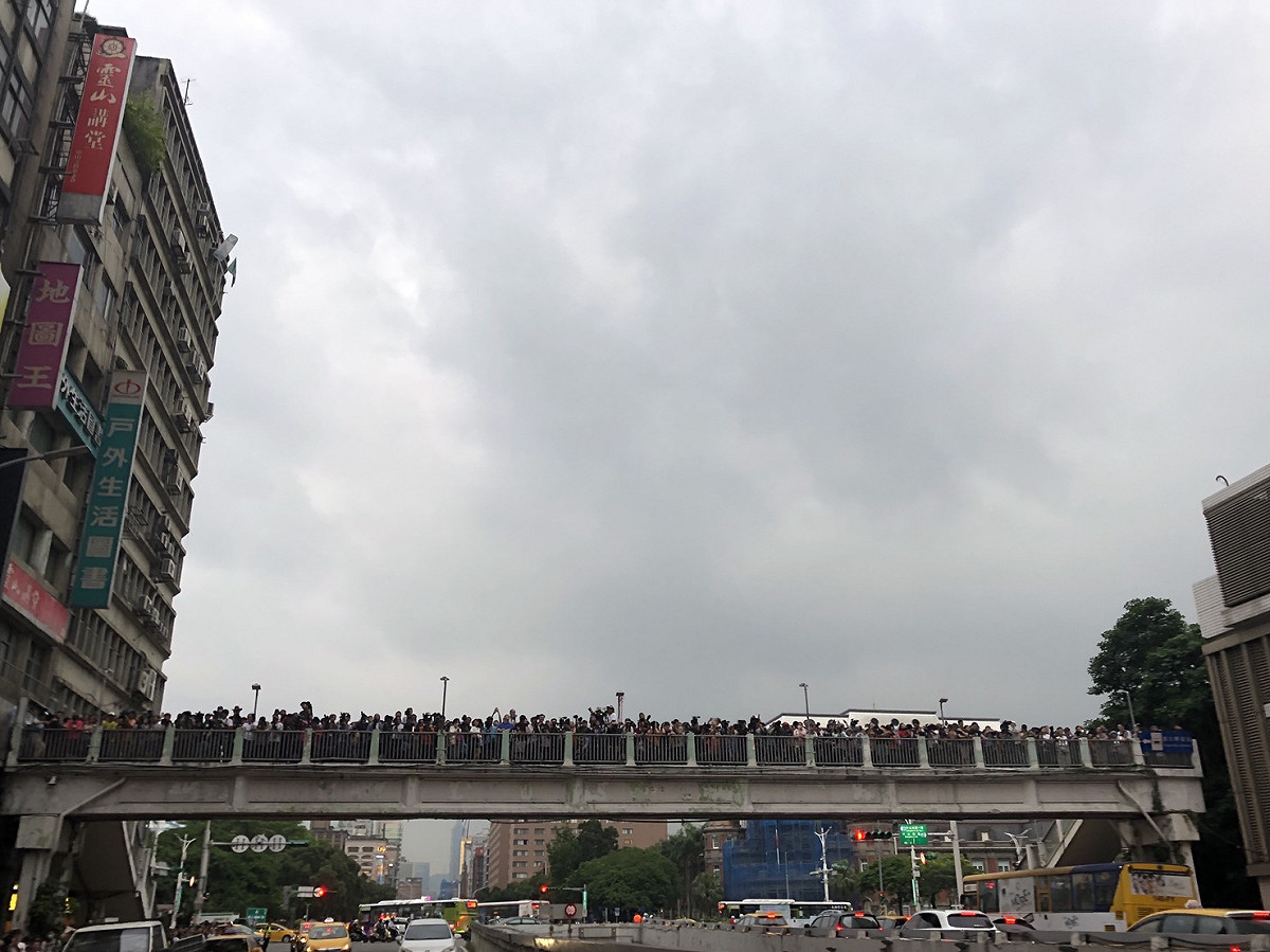昨（29）日忠孝橋上擠滿了搶拍懸日的民眾，然而雲層厚重、太陽僅短暫露臉，使不少民眾敗興而歸。 圖：林芷湲／攝
