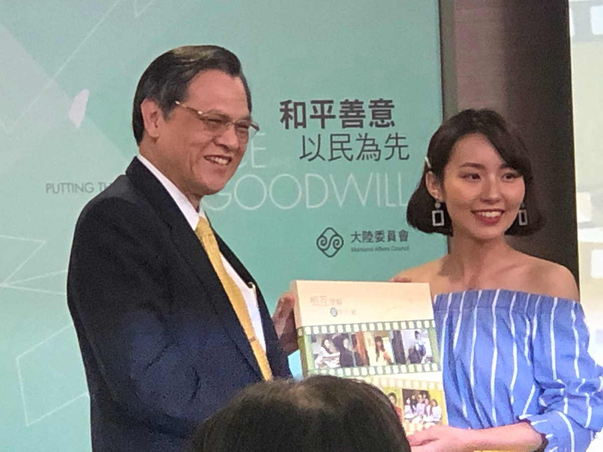 陸委會主委陳明通頒贈微電影「相互理解  愛無距離」特寫照給劇中飾演女兒的新生代演員鍾冰。 圖：謝莉慧/攝
