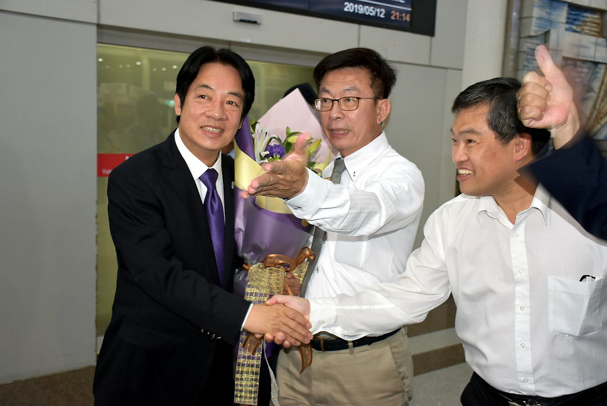 立委郭國文(中)及前高雄市議員蕭永達(右)到場接機。 圖：孫家銘／攝