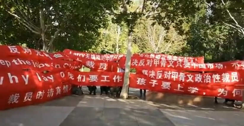 美國軟體公司甲骨文（Oracle）傳出將於22日裁撤中國6成研發人力，引發員工舉布條抗議。 圖：翻攝Youtube