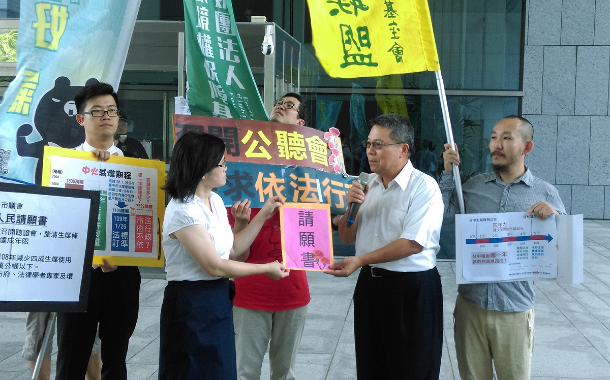 環團向中市議會請願要求召開聽證會，由秘書長張世禎接下請願書。 圖 : 主婦聯盟台中分會/提供