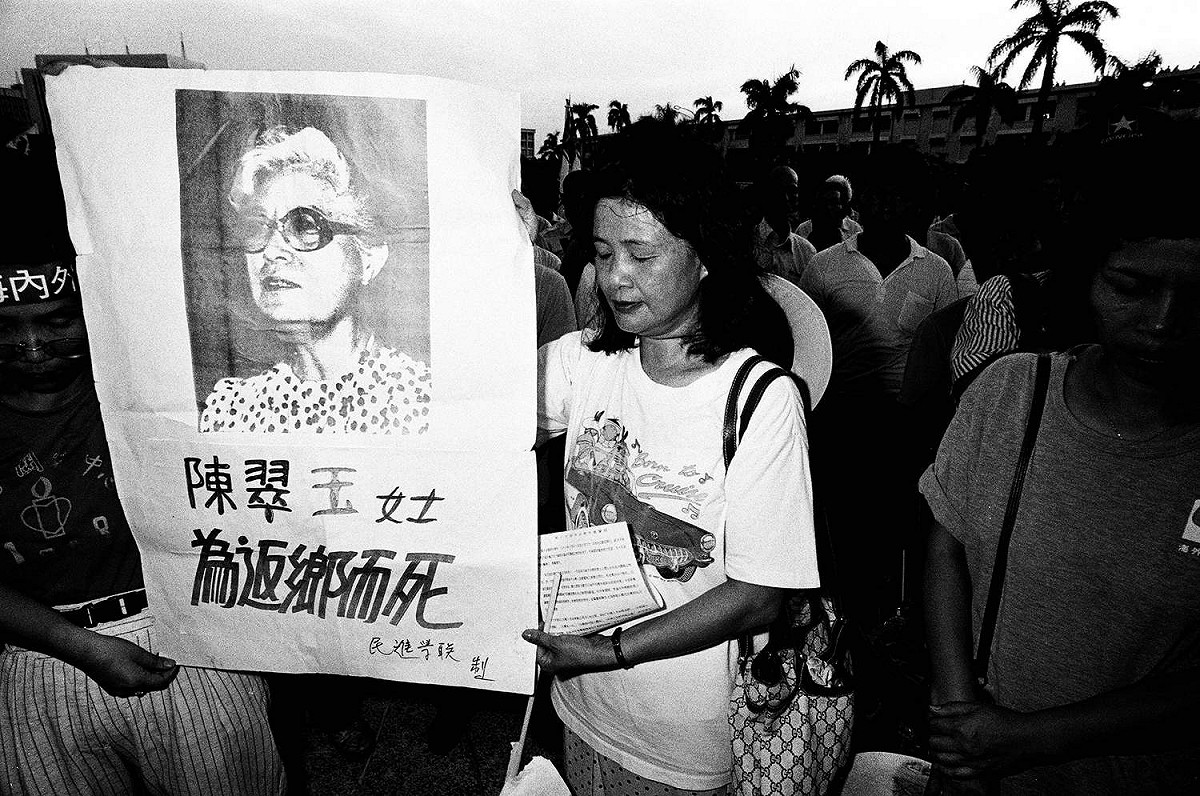 前台獨聯盟主席張燦鍙之妻張丁蘭拿著陳翠玉為返鄉而死布條抗議，彰顯陳翠玉遭黑名單迫害的遭遇。 （圖：邱萬興/攝影）
