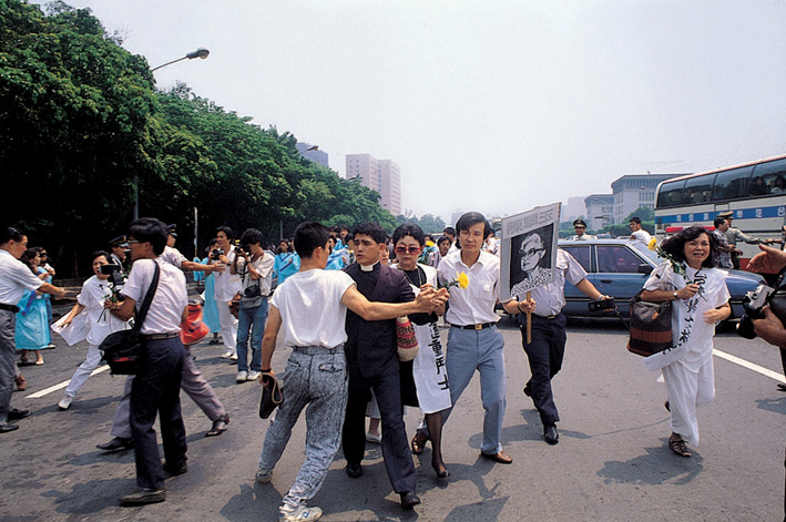 陳翠玉極力返鄉，希望能為台灣民主盡一份心力，但年事已高的她奔波勞頓，身體無法承受勞累而病逝，讓異議人士為之感到不甘，憤而決議衝撞總統府抗議。當時狀況突然，讓軍警措手不及，許多憲兵來不及穿上鎮暴裝，僅穿白色內衣出來攔截。 （圖：邱萬興/攝影）