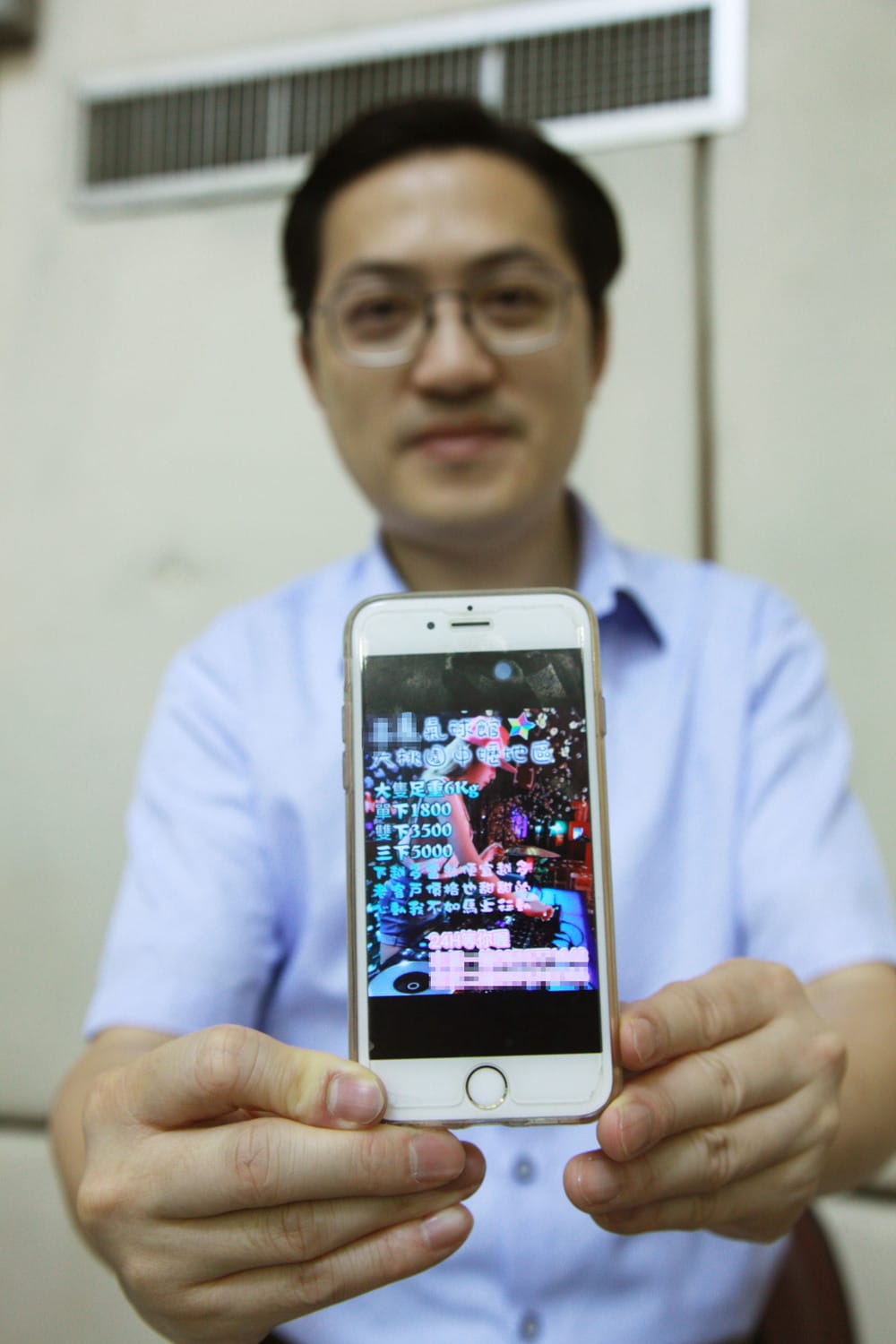 梁為超秀出手機內的笑氣廣告，不知情的人還以為是活動裝飾氣球廠商的廣告。 圖：林昀真／攝