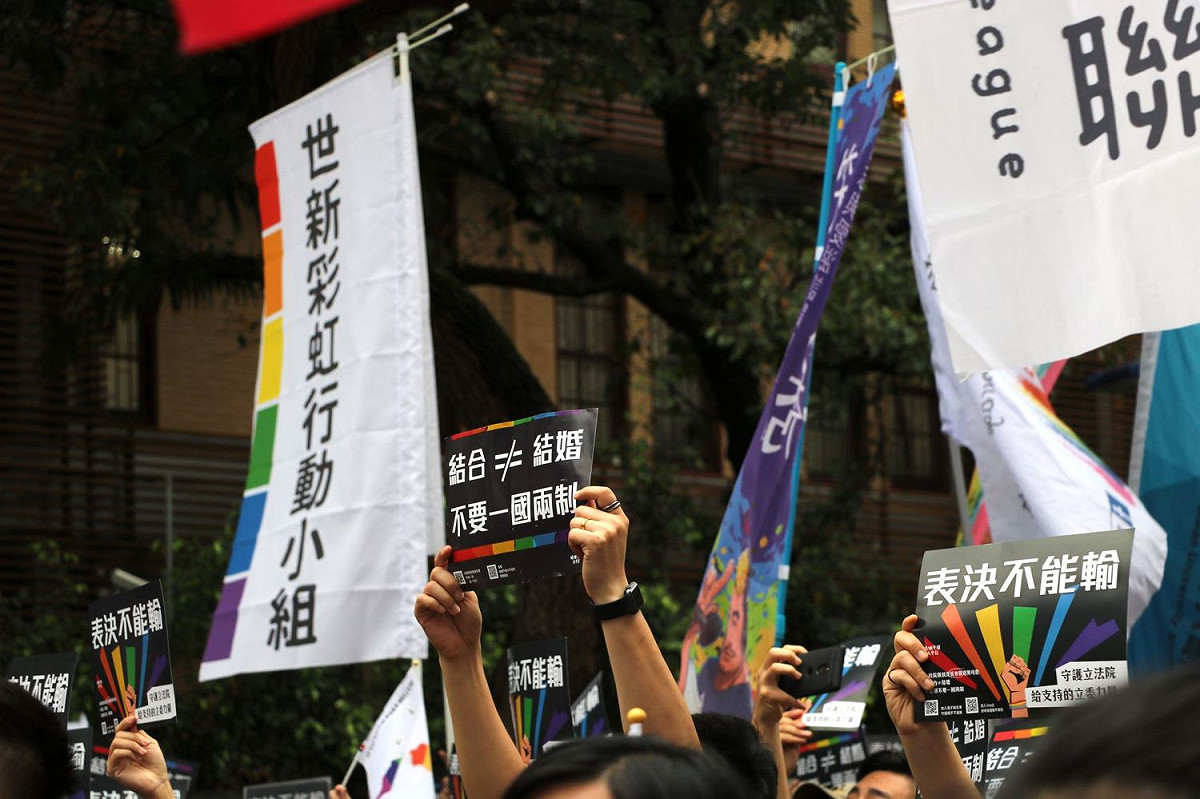 民眾手拿「結合 ≠婚姻、不要一國兩制」的牌子。 圖：婚姻平權大平台提供