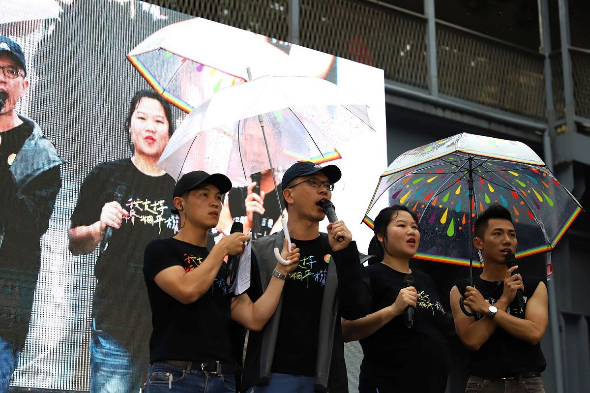 挺同活動主持人冒著大雨呼籲務必要讓法案三讀過關。 圖：婚姻平權大平台提供