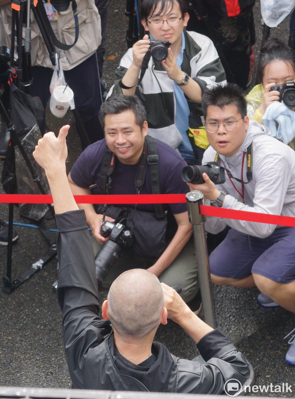 挺同婚專法，知名導演蔡明亮現身立法院前，高舉大拇指鼓勵現場支持者。 圖：張良一 / 攝
