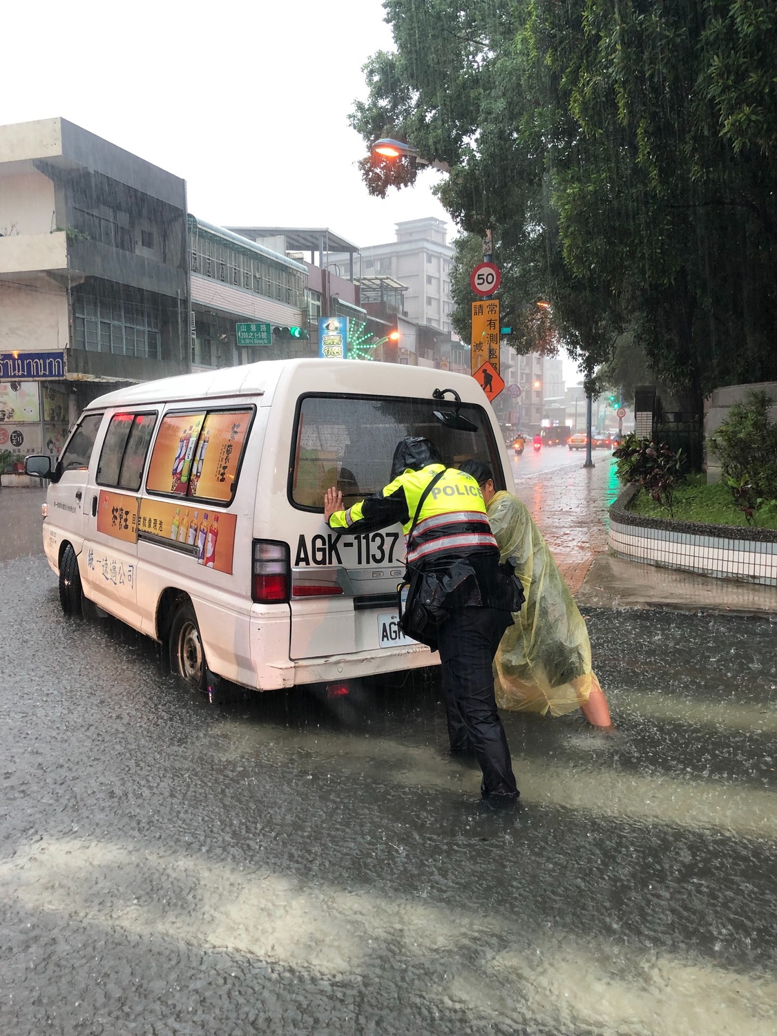 警員林芝妤協助故障車輛推往安全處等待拖吊車移置。 圖：龜山分局／提供