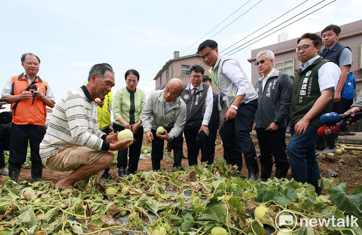 瓜農拿著泡爛的香瓜向行政院長蘇貞昌說明原本再過三天就可以採收的香瓜，這下子因為暴雨，全部泡爛無法採收。 圖：林昀真／攝