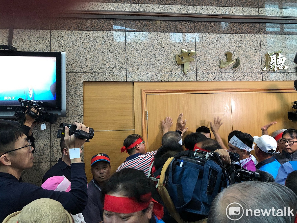 陳抗民眾直接衝入中央黨部一樓，聚集在召開中常會的中山廳前，並輪流5人一組捶門要闖入，要求和主席吳敦義直接對話。 圖：謝莉慧/攝