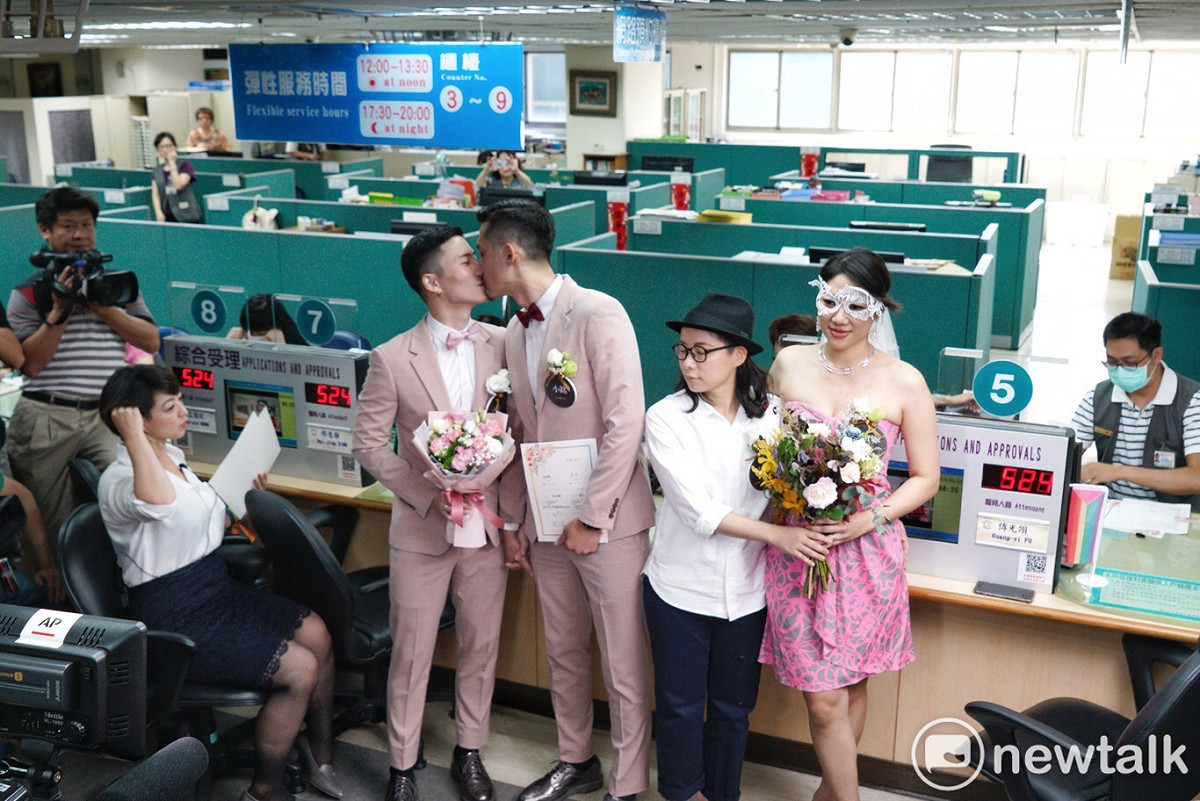信義行政中心同婚登記，同志新人林玄（左1）、袁紹銘（左2）與劇作家簡莉穎（右2）、插畫家厭世姬（右1）前往登記。 圖：張良一 / 攝