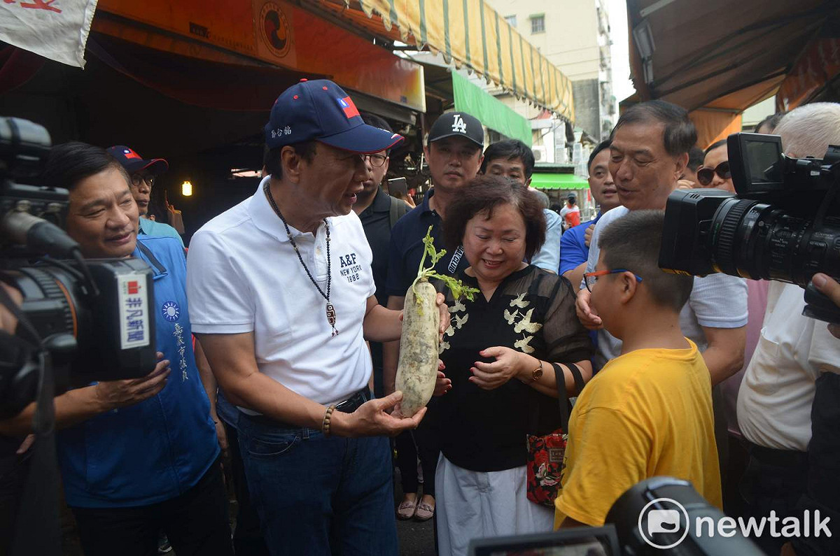 郭台銘今天造訪嘉義東市場，民眾送上菜頭，象徵好彩頭。 圖：蔡坤龍/攝